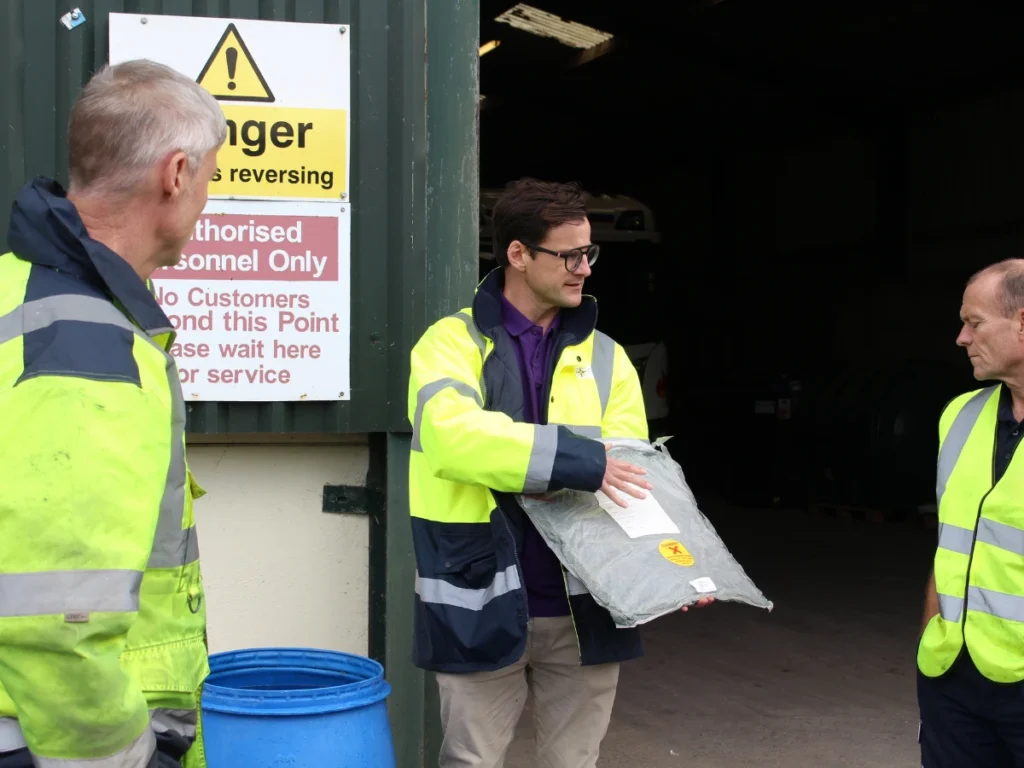 Image shows a spill trainer showing delegates an emergency clay drain mat.