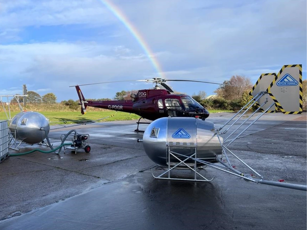 Ayles Fernie Stratus helicopter underslung oil dispersant spray system pictured on the ground with a helicopter during testing